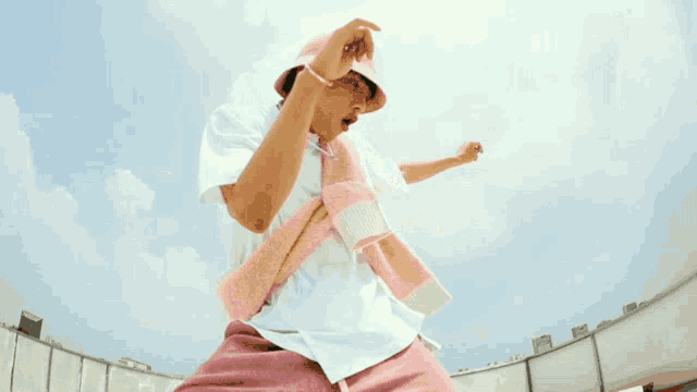 a person wearing a pink shirt and pink shorts is standing on a roof