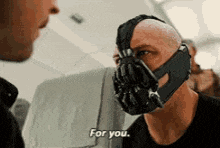 a man wearing a mask is talking to another man and says for you .
