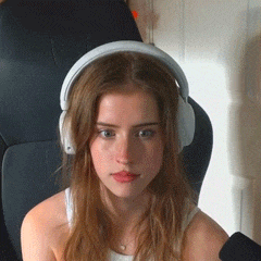a young woman wearing headphones is sitting in a chair .