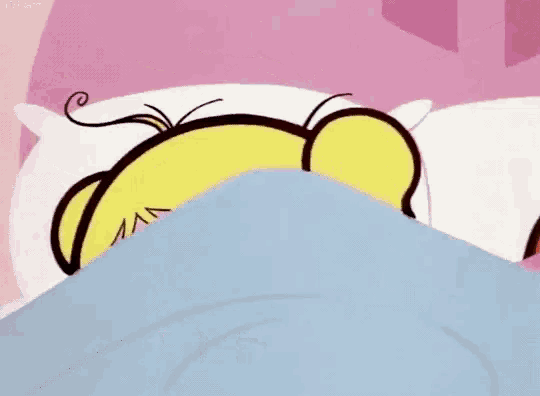 a cartoon character is laying on a bed with a blanket .