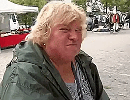 a woman wearing a green jacket is making a funny face .