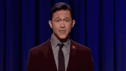 a man in a suit and tie is giving a speech on stage .