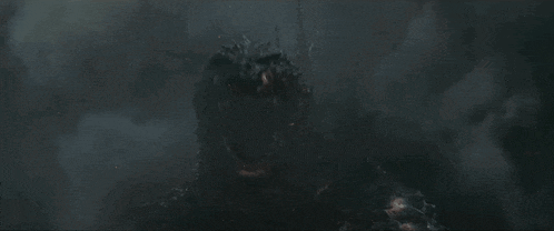 a large monster is standing in the dark with its mouth open and smoke coming out of it 's mouth .