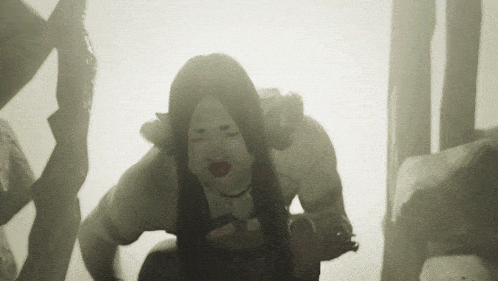 a woman with long hair and red lips is kneeling down