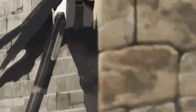 a person is standing next to a brick wall with a ladder .
