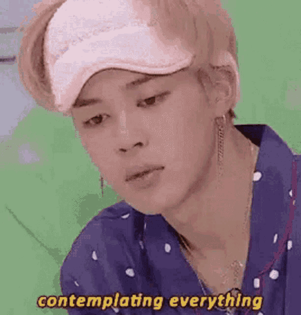 a close up of a person wearing a pink hat and pajamas with the words contemplating everything .
