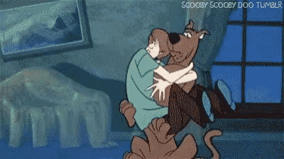 scooby doo is hugging a person in a bedroom .