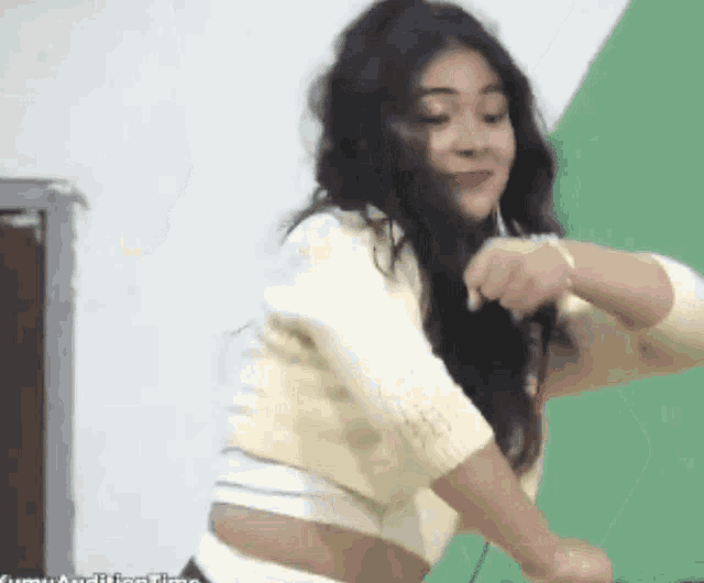 a woman in a white sweater is dancing in front of a green background that says audition time on it