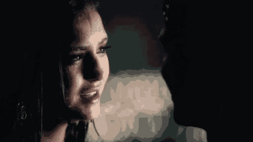 a man and a woman are kissing in the rain in a dark room .