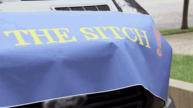 a car with a blue cloth on it that says the stitch