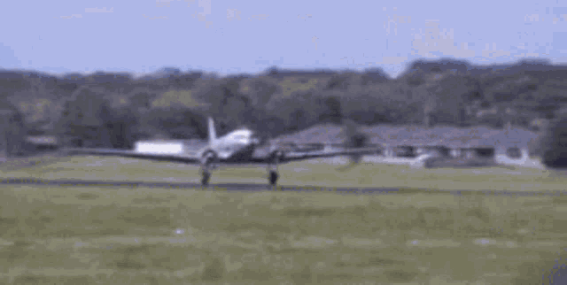 a small plane is taking off from a grassy runway