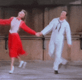 a man and woman are holding hands while dancing