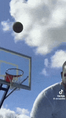 a tiktok video of a man playing basketball with a basketball in the air