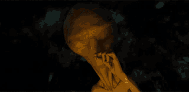 a statue of an alien smoking a cigarette in a dark room