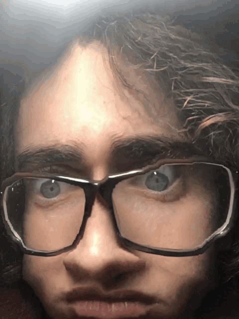 a close up of a person wearing glasses and making a face
