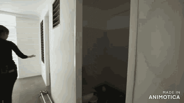 a woman standing in a hallway with the words made in animatica on the bottom right