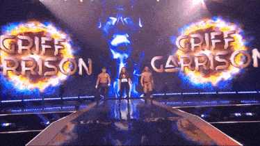 a group of men standing on a stage with griff prison and griff carrison behind them