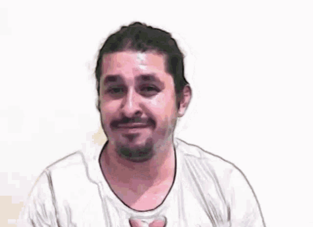 a man with a beard is wearing a white shirt and making a funny face with his hands .