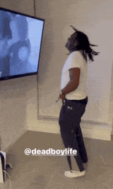 a man is dancing in front of a television with the hashtag deadboylife on the bottom