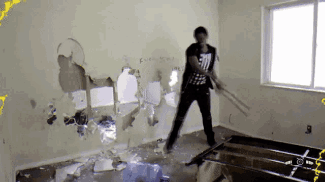 a man is standing in a room with a hole in the wall that says ' fuck you ' on it