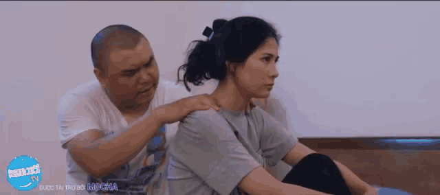 a man is giving a woman a massage in front of a sign that says " mocha "