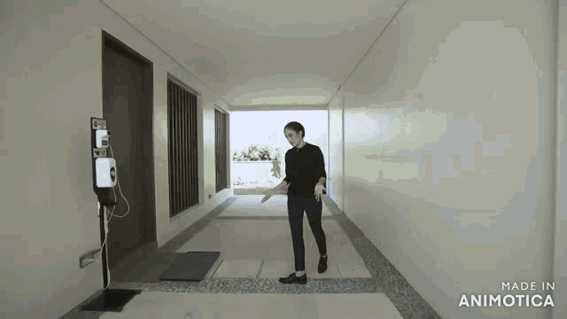 a man is standing in a hallway with the words made in animotica on the bottom