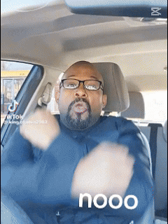 a man with glasses and a beard is sitting in a car with the word nooo written on the bottom