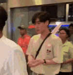 a man is standing in a crowd of people talking to a woman .