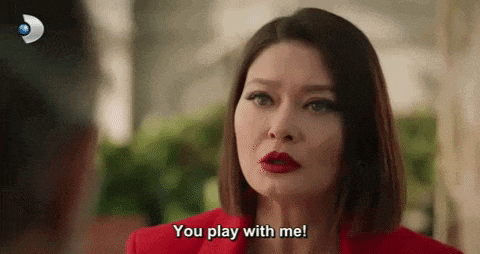 a woman in a red jacket is talking to a man and says `` you play with me ! ''