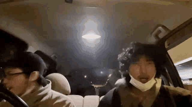 a man with a mask on his face is driving a car