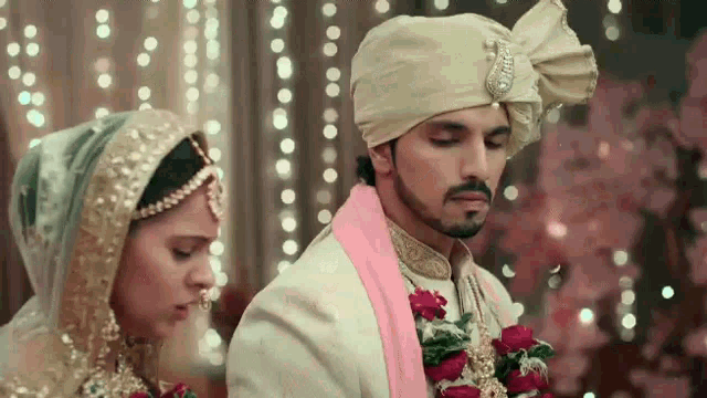 a bride and groom are standing next to each other in a room .