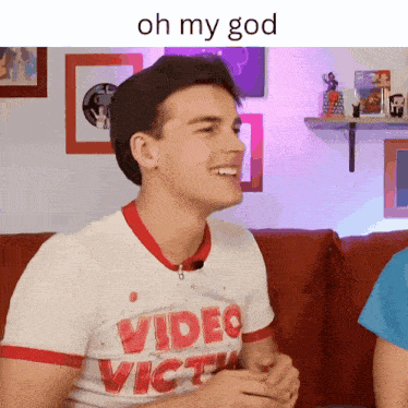 a man wearing a video victim t-shirt is smiling