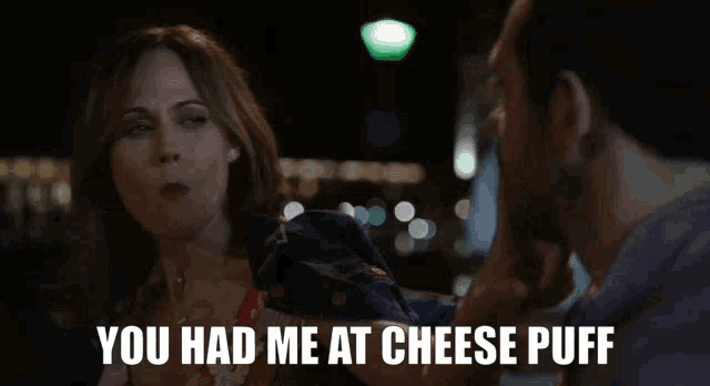 a woman talking to a man with the words " you had me at cheese puff " on the bottom