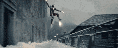 a man in a superhero costume is flying through the air while holding a rocket .