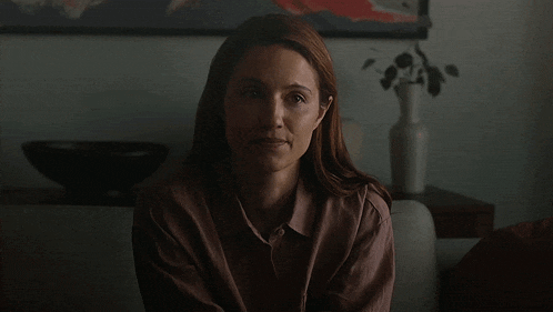 a woman is sitting on a couch in a dark room