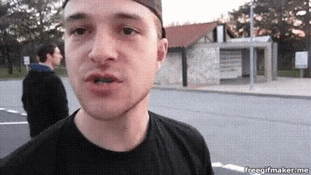 a man in a black shirt is standing in front of a building that says ' freegifmaker.me '