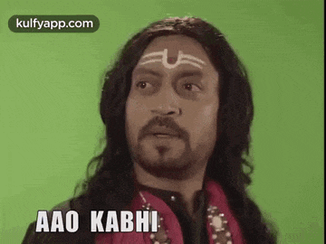 a man with a beard and a tattoo on his forehead is wearing a wig .