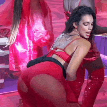 a woman in a red outfit is dancing on a stage with a man in red boots .
