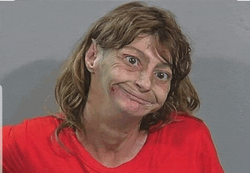 a woman in a red shirt is making a funny face while making a funny face .