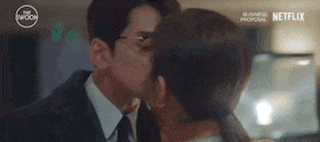 a man and woman are kissing in a room .
