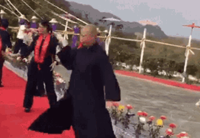 a group of people are standing on a red carpet