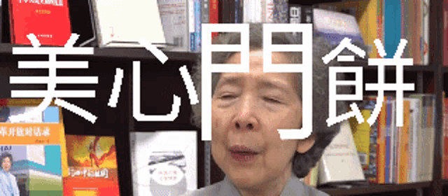 a woman is standing in front of a bookshelf with chinese writing on it