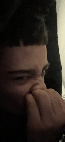 a close up of a person covering their nose