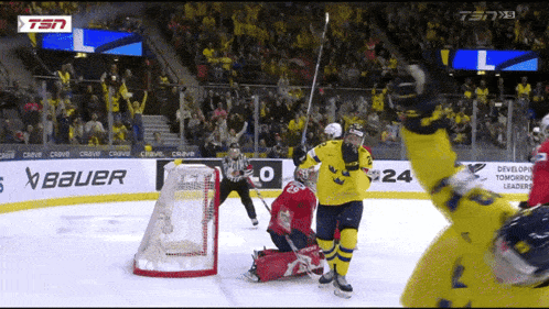 a hockey game is being played in front of a bauer banner
