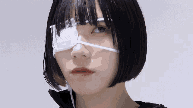 a girl with a bandage on her eye is looking at the camera