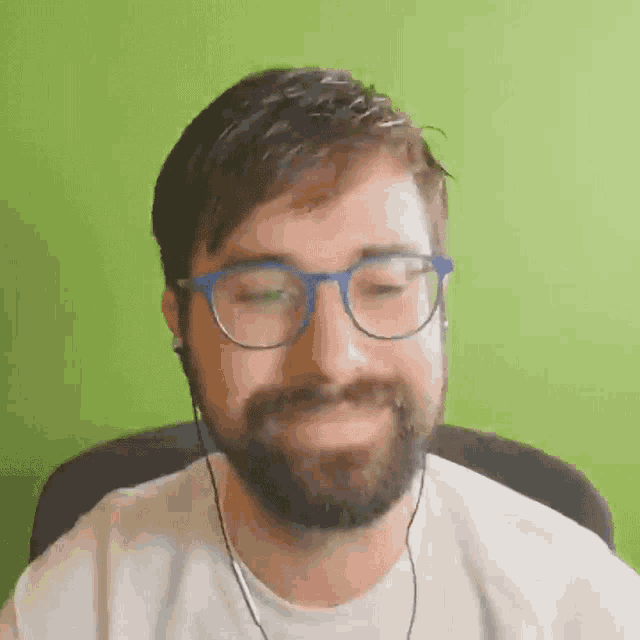a man with a beard is wearing glasses and headphones .