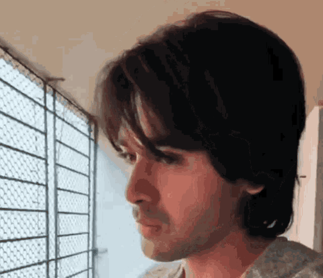 a close up of a man 's face looking out a window
