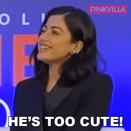 a woman says he 's too cute in front of a blue background