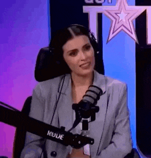 a woman is sitting in front of a microphone and wearing headphones .