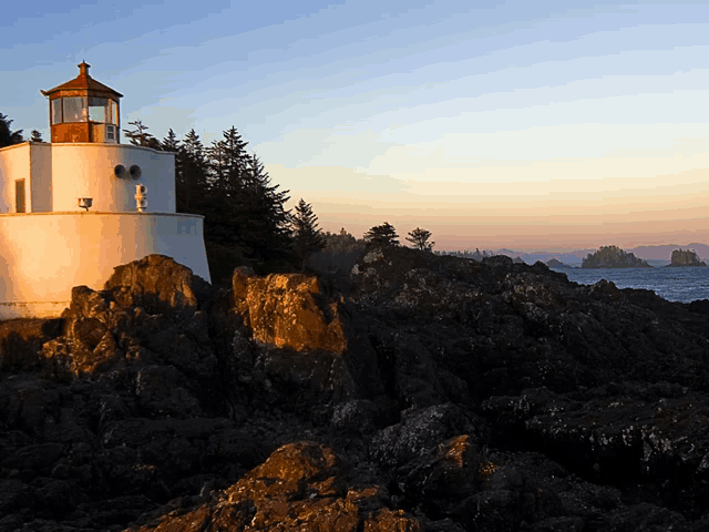 a lighthouse sits on a rocky cliff overlooking a body of water